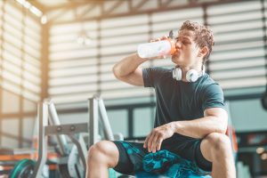 Man taking a pre-workout supplement at the gym